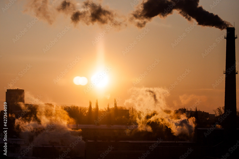 Fototapeta premium steam from a pipe in the light of dawn, urban landscape