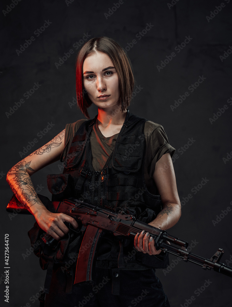 Armed with rifle attractive woman in dark background
