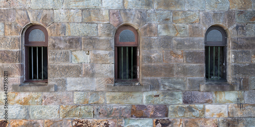 windows with metal bars in a sandstone wall 
