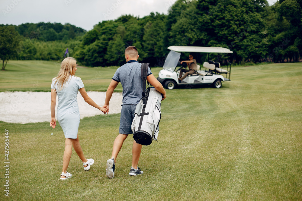 Obraz premium Beautiful couple playing golf on a golf course