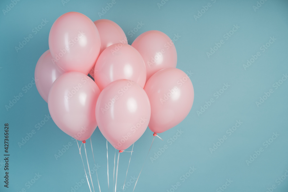 Pink balloons on a blue background with copy space for text. Pink pastel balloons, free space. Happy holiday of flying balloons