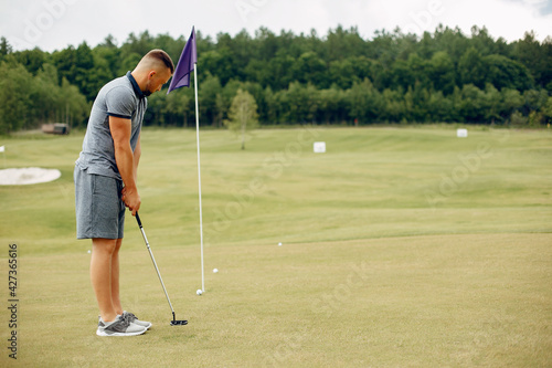 Handsome man playing golf on a golf course