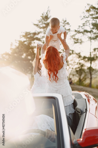 Family in a cabriolet convertible car at the sunset © hetmanstock2