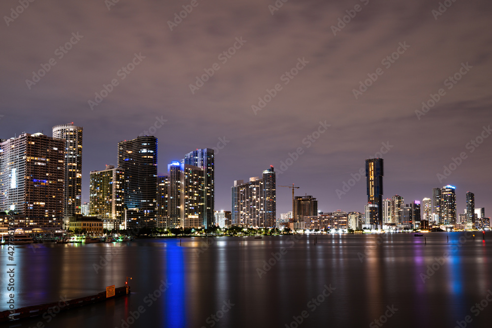 Miami Florida, sunset panorama with colorful illuminated business and residential buildings and bridge on Biscayne Bay. Miami night.