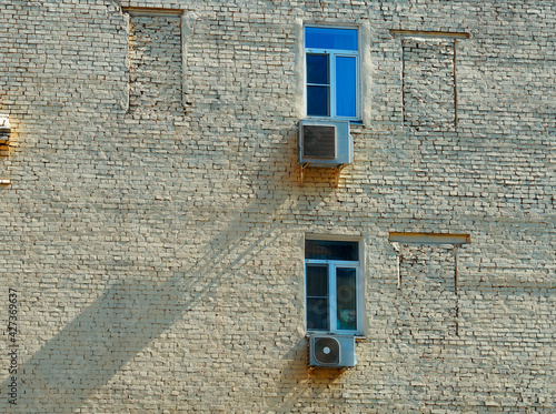 Two closed windows brick building background