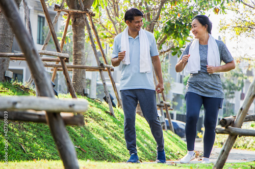 A couple of older Asian men and women wear exercise clothes before their morning exercises.Men and women jogging in the morning in the garden.