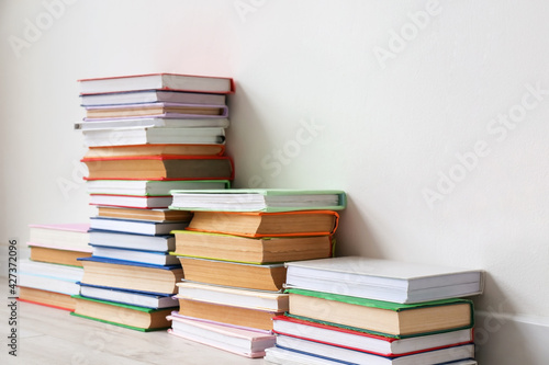 Stack of books near light wall in room