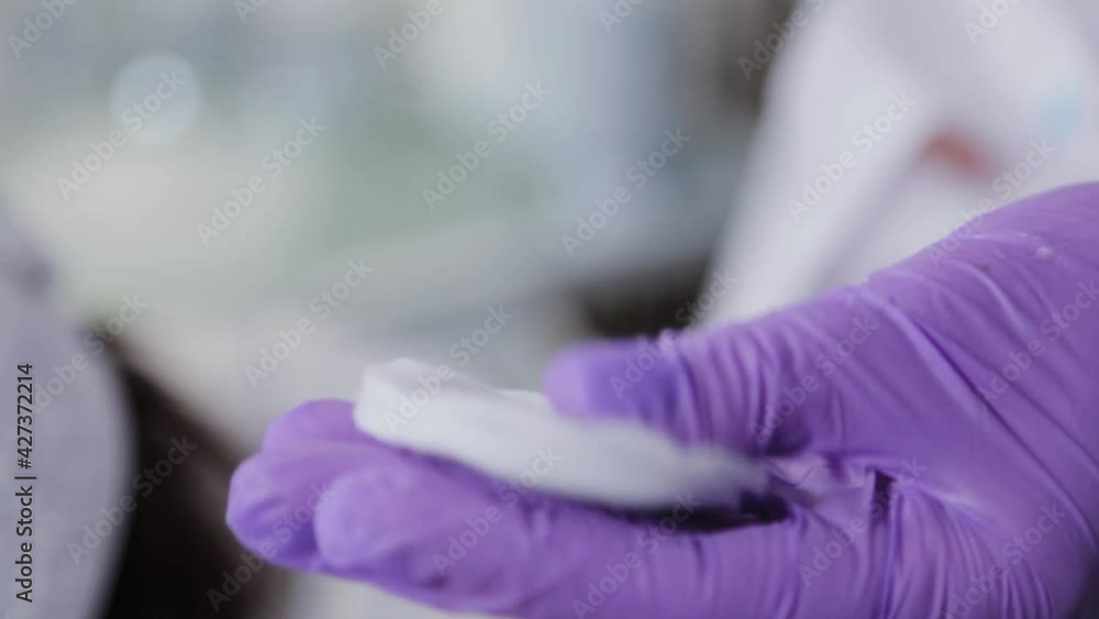 Professional beautician woman pours tonic on cotton pads. Professional beautician woman pours tonic on cotton pads.