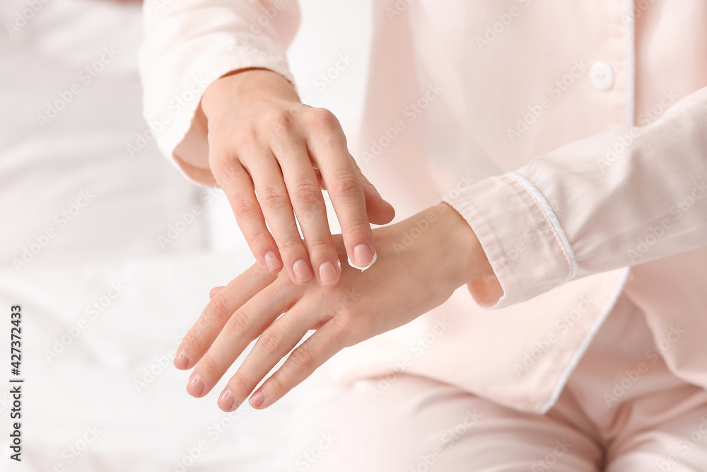 Young woman applying cream on her hands, closeup Young woman applying cream on her hands, closeup