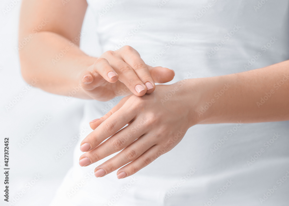 Young woman applying cream on her hands, closeup Young woman applying cream on her hands, closeup