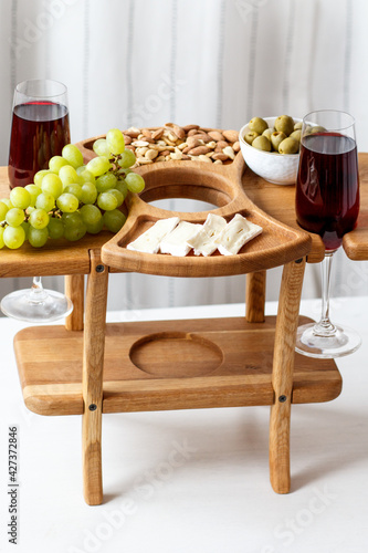 Serving wooden table for wine, glasses and snacks. Handmade segmented Portion wooden table. Grapes, cheese, wine and nuts.  