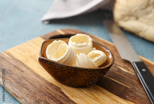 Bowl with fresh butter on wooden background, closeup