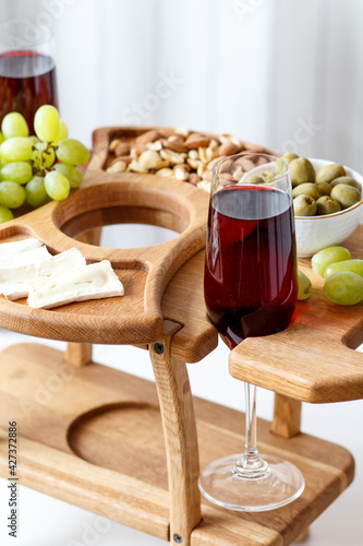 Serving wooden table for wine, glasses and snacks. Handmade segmented Portion wooden table. Grapes, cheese, wine and nuts.  