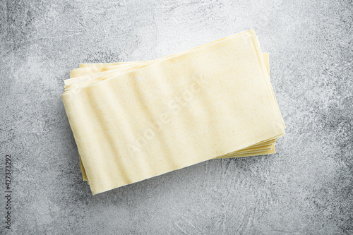 Organic lasagna pasta sheets, on gray stone background, top view, flat lay