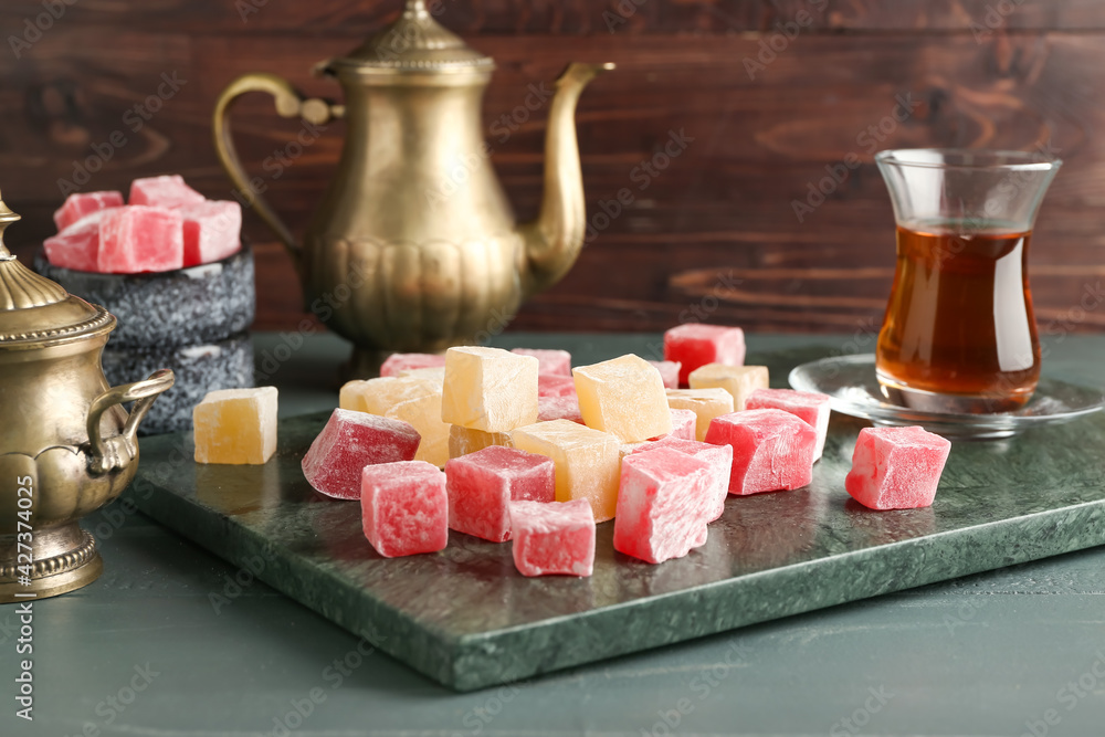Composition with Turkish delight and cup of tea on table Composition with Turkish delight and cup of tea on table