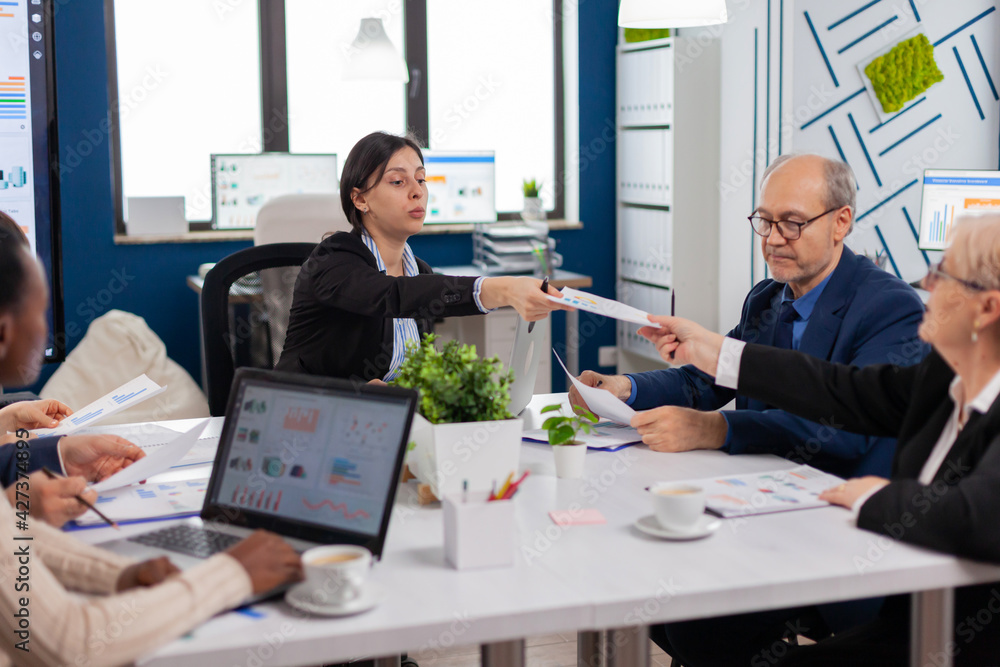 Group of diverse business people having a meeting in conference room. Businesswoman discussing ideas with colleagues about financial strategy for new start up company. Group of diverse business people having a meeting in conference room. Businesswoman discussing ideas with colleagues about financial strategy for new start up company.