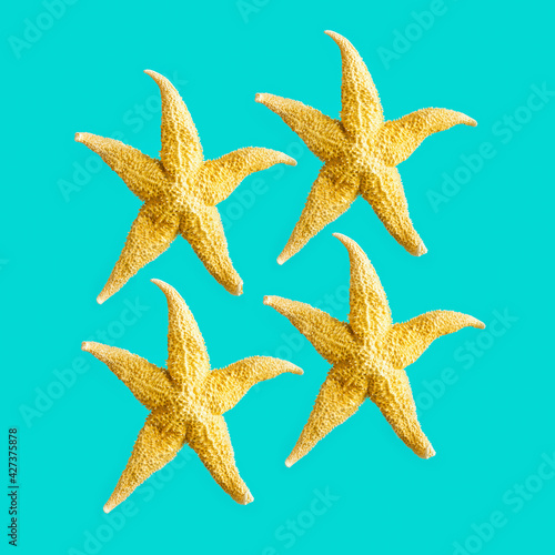 Bright summer pattern with sea stars. Yellow starfish on turquoise, sea summer vacation concept.