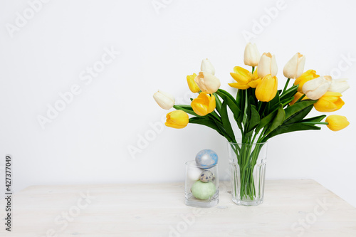 Yellow tulips in a vase and Easter eggs Copy Space