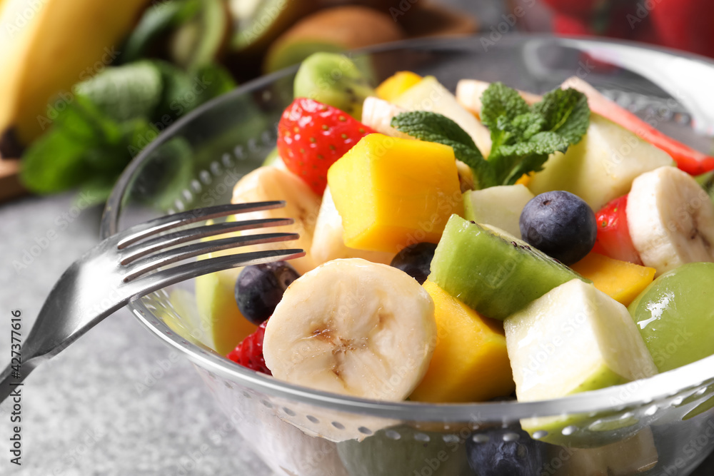 Delicious fresh fruit salad in bowl on table, closeup Delicious fresh fruit salad in bowl on table, closeup