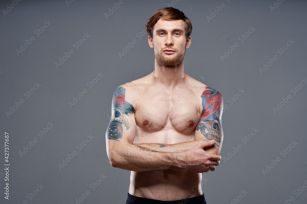 man with tattoos on his arms pumped up torso workout cropped view bodybuilder