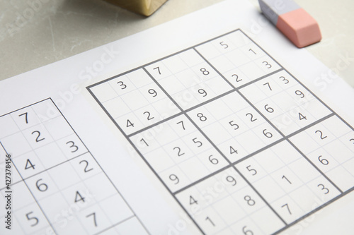 Sudoku and eraser on light table, closeup