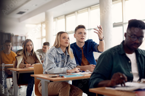 University classmates talking while having lecture in the classroom.