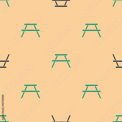 Green and black Picnic table with benches on either side of the table icon isolated seamless pattern on beige background. Vector