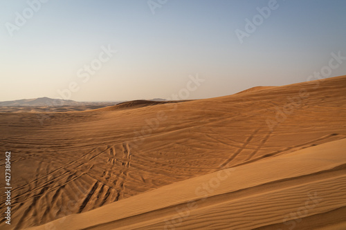 andscape of desert dunes at sunset on a windy day