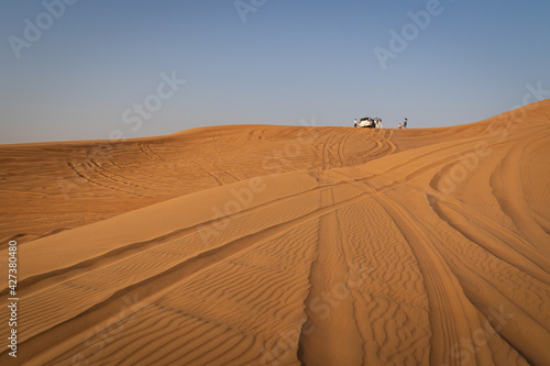 Desert safari tour in UAE. Four wheel drive desert safari car on a san dune with a tourists