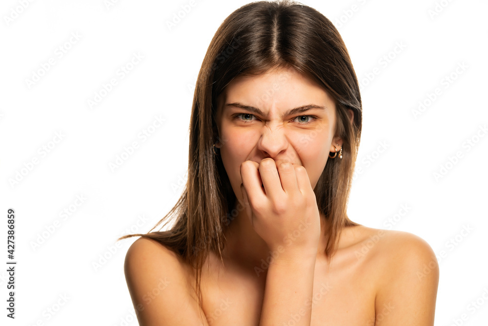 A young beautiful girl is biting her nails A young beautiful girl is biting her nails
