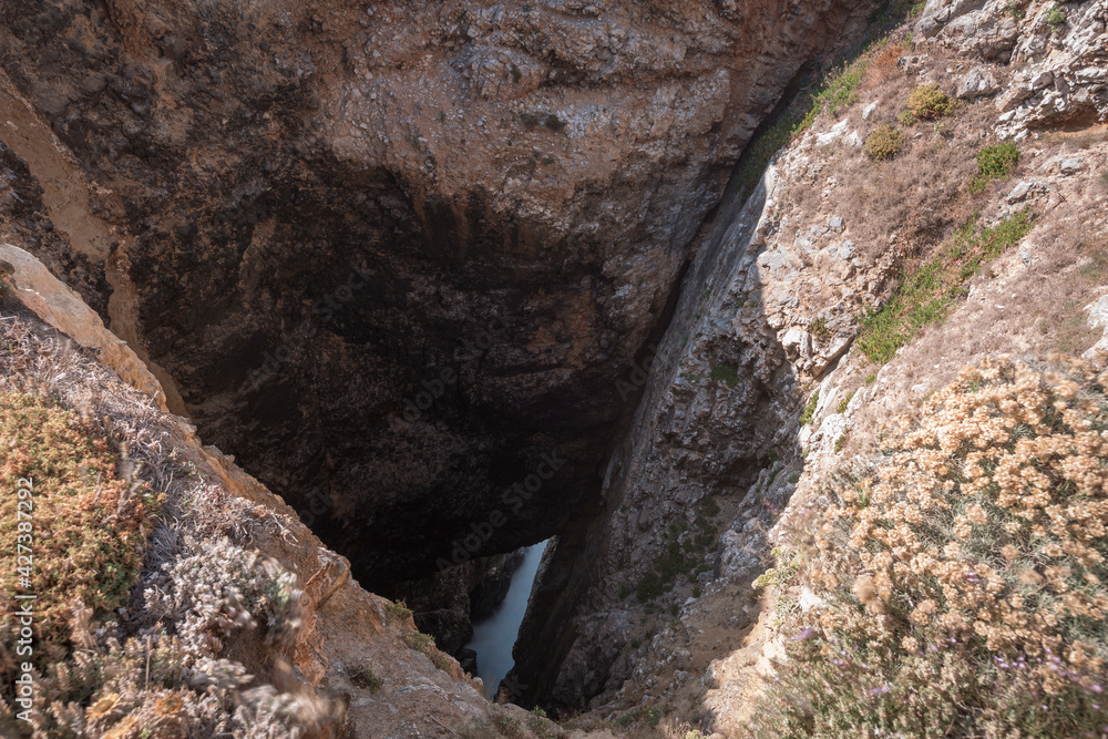A huge hole in the ground that reach the sea level , close to Praia Da Andraga