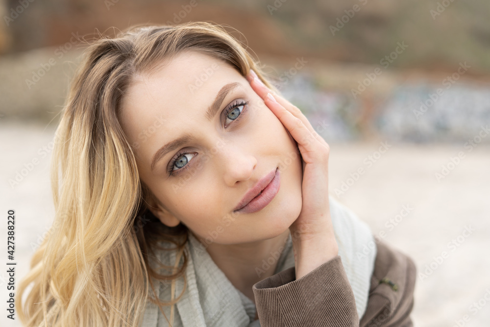 Portrait of a charming young woman looking in the camera with a beautiful blue eyes and blonde hair with cute smile Portrait of a charming young woman looking in the camera with a beautiful blue eyes and blonde hair with cute smile