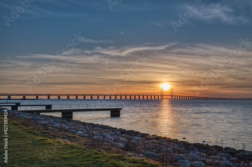 Sunset on the Oresund Bridge (Oresundsbron) in the Baltic Sea. The road rail overpass connects Malmo to Copenhagen across the Oresund Strait and border commuters or frontier workers cross it daily © Roberto