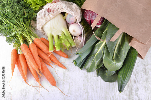 vegetables in a  paper bag among other  fresh vegetables