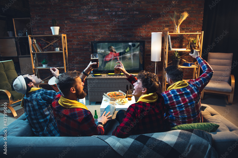 Group of friends watching TV, sport match together. Emotional fans cheering for favourite team, watching on exciting game. Concept of friendship, leisure activity, emotions
