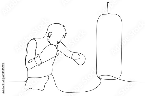 man stands next to a punching bag - one line drawing vector. a boxer trains with a punching bag, he stands, gloves on hands