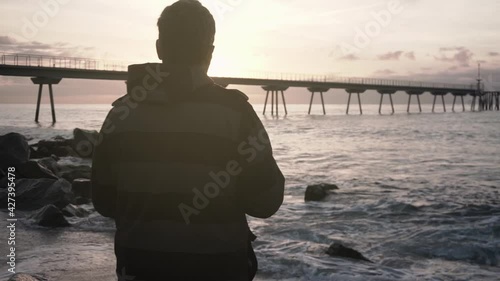 Photographer taking pictures of the sunrise and seascape at the beach