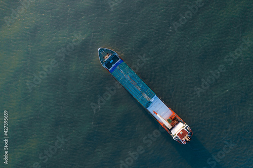 Photo aérienne panoramique ultra grand angle par drone d'un porte-conteneurs industriel naviguant en pleine mer dans le bleu profond de l'océan photo