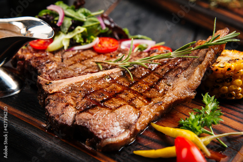 Closeup on grilled beef steak with vegetables and sauce