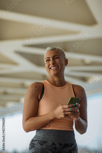 Sporty woman using phone outdoors