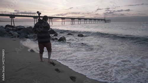 Photographer setting up the tripod and camera at the beach for a sunrise photoshoot