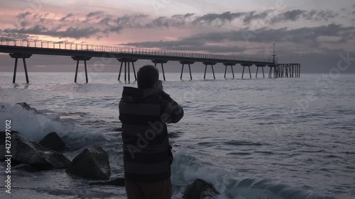 Photographer taking pictures of the sunrise and seascape at the beach