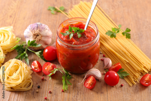 tomato sauce and pasta on wood background
