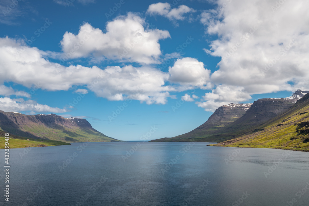 Ocean fjord of Seydisfjordur, Iceland, on a warm, partly cloudy day.