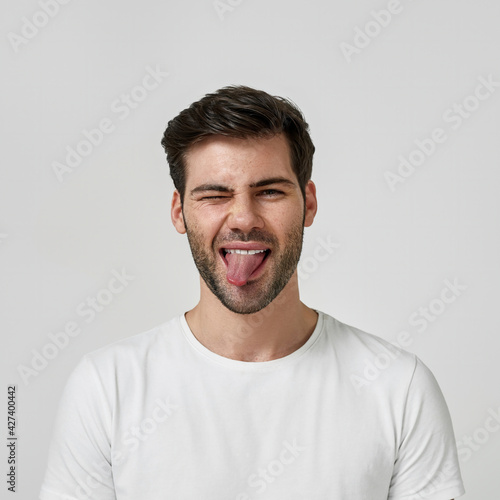 Man in a white t-shirt showing his tongue