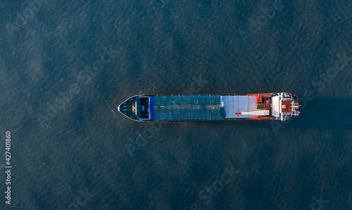 Photo aérienne panoramique ultra large par drone d'un porte-conteneurs industriel naviguant en pleine mer dans le bleu profond de l'océan