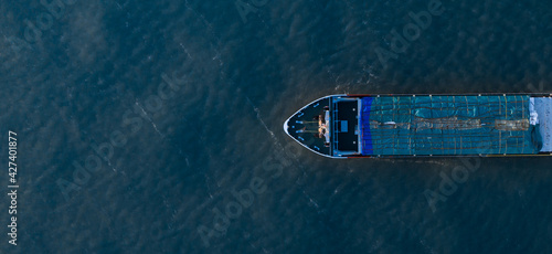 Photo aérienne panoramique ultra large par drone d'un porte-conteneurs industriel naviguant en pleine mer dans le bleu profond de l'océan