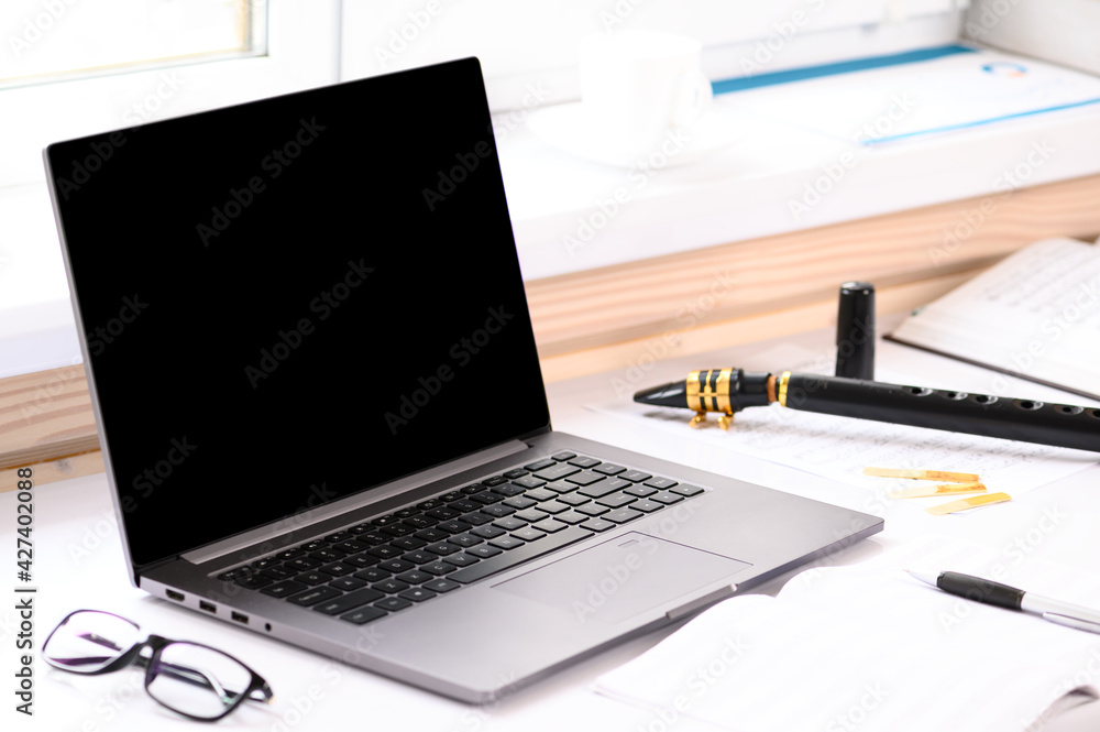 . Musical instrument playing courses. On the table there is a laptop and supplies for the lesson. Online learning. . Musical instrument playing courses. On the table there is a laptop and supplies for the lesson. Online learning.