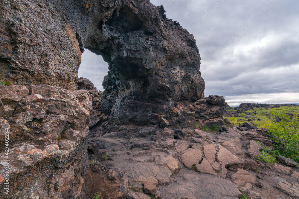 Basalt arch in the Dimmu Borgir area of northern Iceland. Cold and cloudy day in volcanic land.