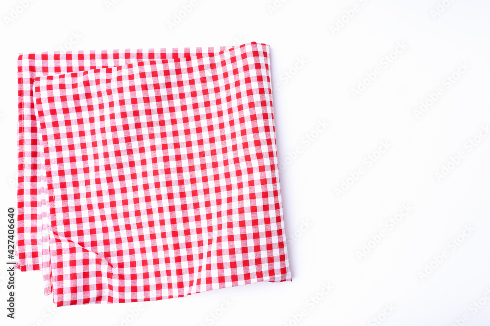 The tablecloth checkered red and white fabric cotton folded place on a white table with copy space. The tablecloth checkered red and white fabric cotton folded place on a white table with copy space.